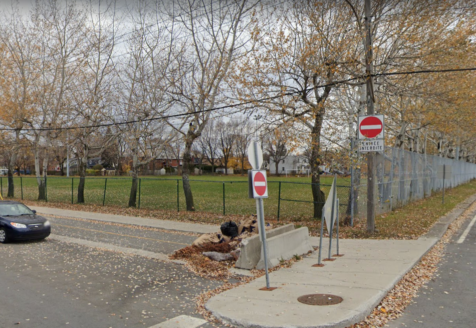 Une piste cyclable se terminant en cul-de-sac vis-à-vis un parc.